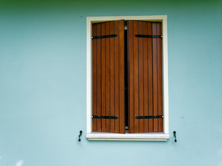 Window of an italian house on a blue wall