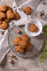 Biscuit hearts. Crispy and crumbly delicious cookies with natural ingredients: flour, nuts, seeds, pieces of chocolate, cocoa, fruit jams. Spring flower still life