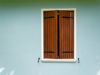 Window of an italian house on a blue wall