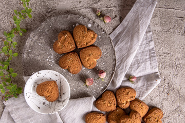 Biscuit hearts. Crispy and crumbly delicious cookies with natural ingredients: flour, nuts, seeds, pieces of chocolate, cocoa, fruit jams. Spring flower still life