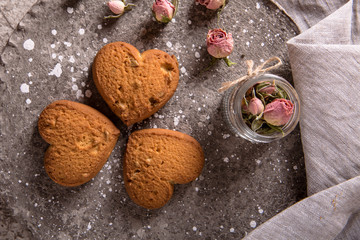 Biscuit hearts. Crispy and crumbly delicious cookies with natural ingredients: flour, nuts, seeds, pieces of chocolate, cocoa, fruit jams. Spring flower still life