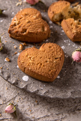 Biscuit hearts. Crispy and crumbly delicious cookies with natural ingredients: flour, nuts, seeds, pieces of chocolate, cocoa, fruit jams. Spring flower still life