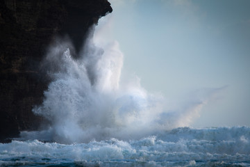 Huge waves crashing against the rocks at Piha beach, Waitakere, New Zealand