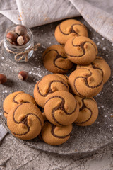 Сhocolate nut biscuit. Crispy and crumbly delicious cookies with natural ingredients: flour, nuts, seeds, pieces of chocolate, cocoa, fruit jams. Spring Flower Still Life