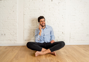 Hipster young man talking on mobile phone happy in his new empty apartment proud of his investment