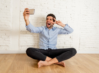Happy hipster young man taking selfie in his new apartment proud of his investment