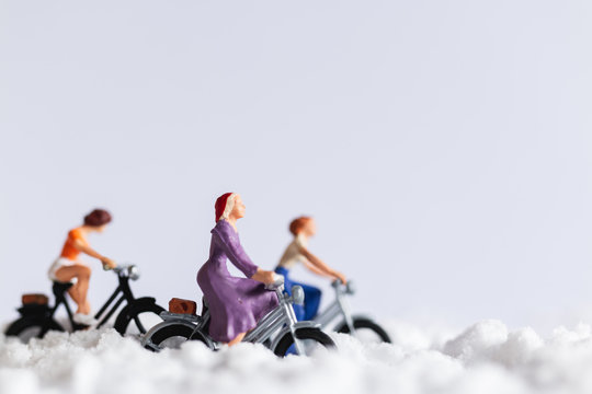 Miniature people : Travelers riding a bicycle on snow , winter background concept