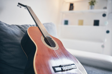 Acoustic guitar on a living room couch / sofa.