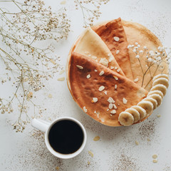 Pancakes and a cup of coffe on a white table food flatlay