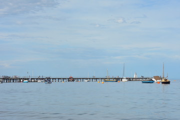 Obraz premium Recreational vessels moored around retired long industrial wharf.