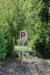 Fototapeta na wymiar Panneau en bois Parking et panneau en bois réception, nature.