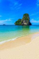 Naklejka premium Ao Phra Nang Beach - Thai traditional wooden longtail boat on Railay Peninsula in front of Limestone karst rocks, close to Ao Nang, Krabi province, Andaman Sea, Thailand