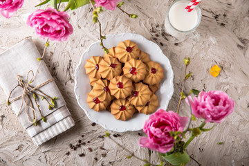 Fototapeta na wymiar Biscuit with strawberry filling. Crispy and crumbly delicious cookies with natural ingredients: flour, nuts, seeds, pieces of chocolate, cocoa, fruit jams. Spring Flower Still Life