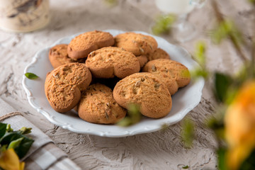 Biscuit hearts. Crispy and crumbly delicious cookies with natural ingredients: flour, nuts, seeds, pieces of chocolate, cocoa, fruit jams. Spring flower still life