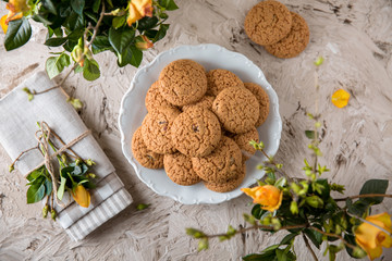 Oatmeal Biscuit. Crispy and crumbly delicious cookies with natural ingredients: flour, nuts, seeds, pieces of chocolate, cocoa, fruit jams. Spring flower still life