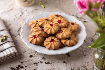 Biscuit with strawberry filling. Crispy and crumbly delicious cookies with natural ingredients: flour, nuts, seeds, pieces of chocolate, cocoa, fruit jams. Spring Flower Still Life