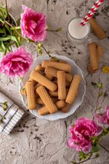 Fototapeta na wymiar Biscuit sticks with fruit filling. Crispy and crumbly delicious cookies with natural ingredients: flour, nuts, seeds, pieces of chocolate, cocoa, fruit jams. Spring Flower Still Life