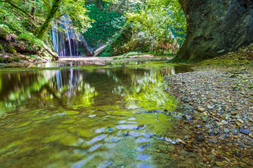 Obraz premium Waterfall surrounded by greenery. Acquacaduta. Friuli, Italy
