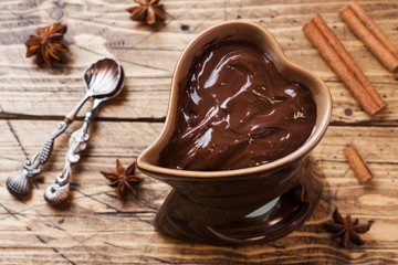 Chocolate paste with cinnamon and anise. Fondue with chocolate on a wooden table. copy space