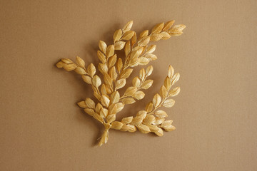 Decoration of straw on a beige background. Branch with leaves is made of straw. Decor.
