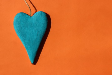 Wooden blue heart on an orange background