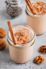 Healthy carrot cake smoothie with walnuts, cinnamon and chia seeds in glass jars