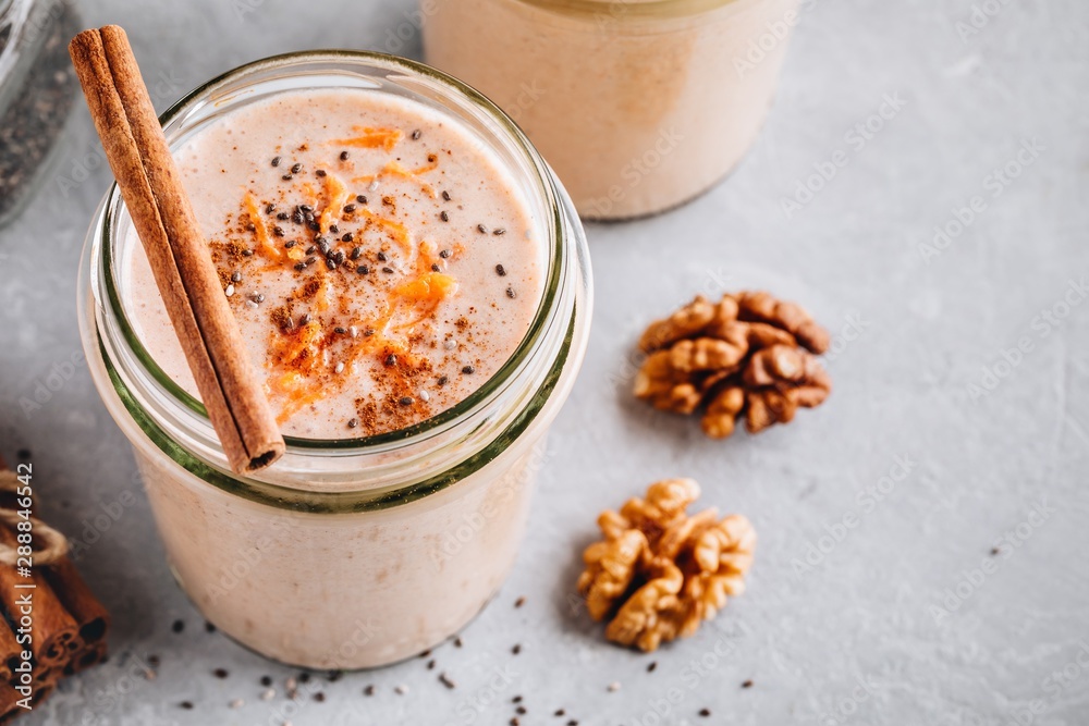 Wall mural Healthy carrot cake smoothie with walnuts, cinnamon and chia seeds in glass jars - Wall murals