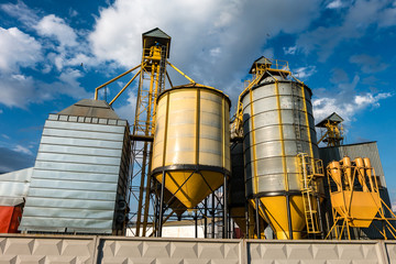 agro-processing plant for processing and silos for drying cleaning and storage of agricultural products, flour, cereals and grain with beautiful clouds © hiv360