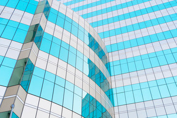 Obraz premium Abstract background from blue glasses window in modern building with sky and clouds reflection.
