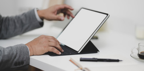 Cropped view of professional businessman working on his project with blank screen tablet