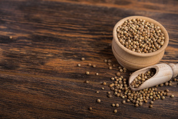 coriander seeds in wooden bowl