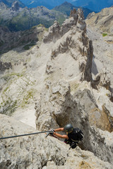 attractive female climber on a steep Via Ferrata in the Italian Dolomites