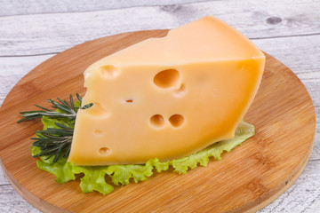 Maasdam cheese  in the board served salad leaves