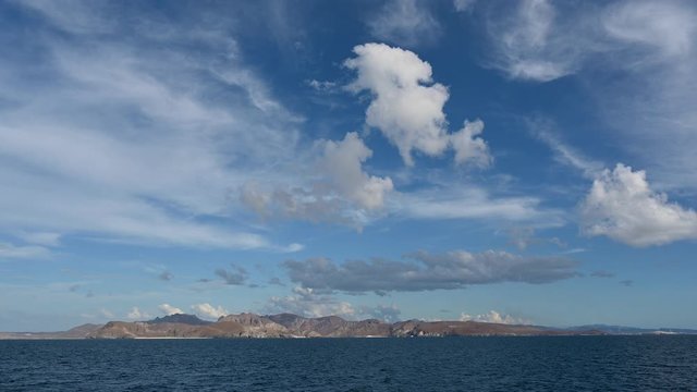 The view of the clouds forming above the Tecolote Beach while sailing towards La Paz, Baja California, Mexico.