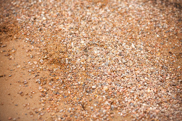 Sand and stones. Yellow sand and small stones on the beach.