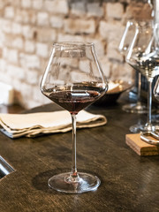 A glass of red wine is on the table in the wine bar.
