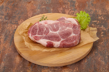 Raw pork steak over wooden board