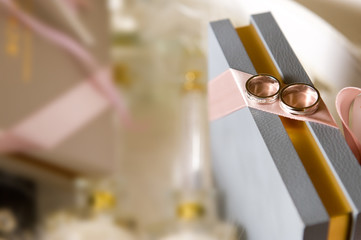 two wedding rings lie on the end of the gift box. copy space