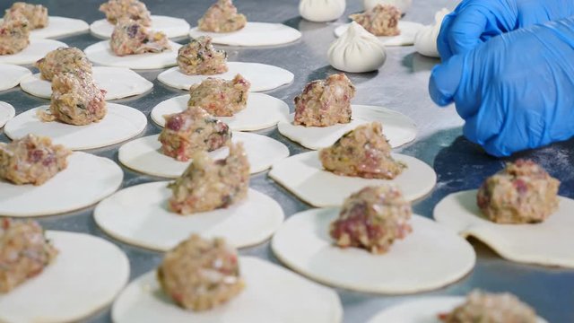 Chief cook making khinkali or meat dumplings. Close up. National Georgian cuisine. Female chief making forms of dumplings with fingers. 4k