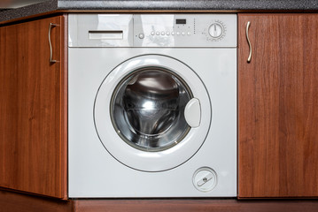 A washing machine integrated in the kitchen furniture