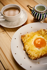 breakfast set with coffee and toast with egg on wooden table