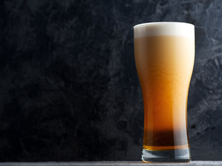 Nitrogen beer in a glass on a dark background with copyspace