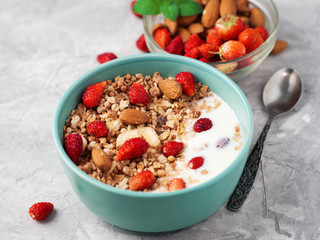 Cup of muesli with yogurt and strawberries with almonds