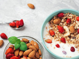Cup of muesli with yogurt and strawberries with almonds