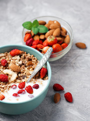 Cup of muesli with yogurt and strawberries with almonds