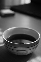 big round bowl with tea, bw photo.