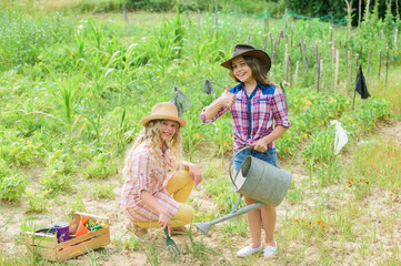 Like what you do. protect nature. Rich harvest. happy farming. spring country side. small girls farmer in village garden. earth day. summer family farm. children work in field use gardening tool