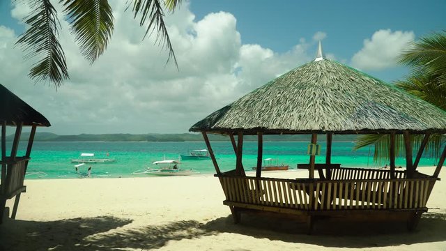 Bungalow on a tropical beach with palm trees and blue sea of Daco, Philippines. Summer and travel vacation concept