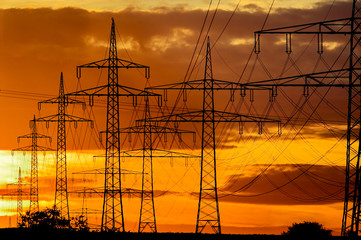 Strommasten zeichnen sich vor dem Abendhimmel ab