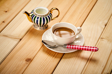 Small cup with aromatic coffee with milk on wooden table
